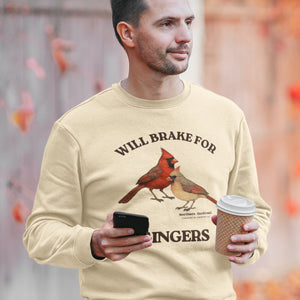 Man wearing a beige sweatshirt with a cardinal design and text, holding a phone and coffee cup.