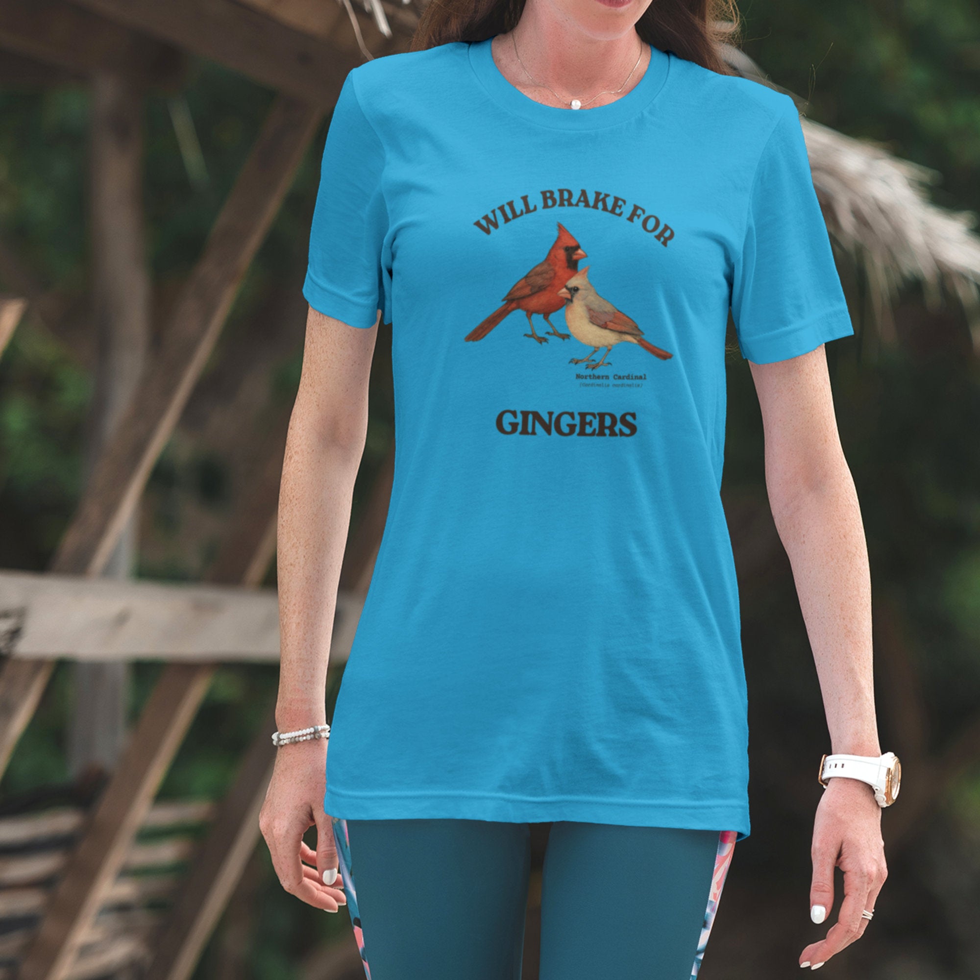 Person wearing a blue t-shirt with cardinal design and text outdoors