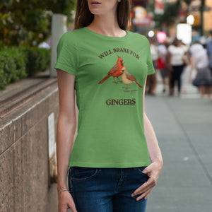 Person wearing a green t-shirt with cardinal design and text on a city street.