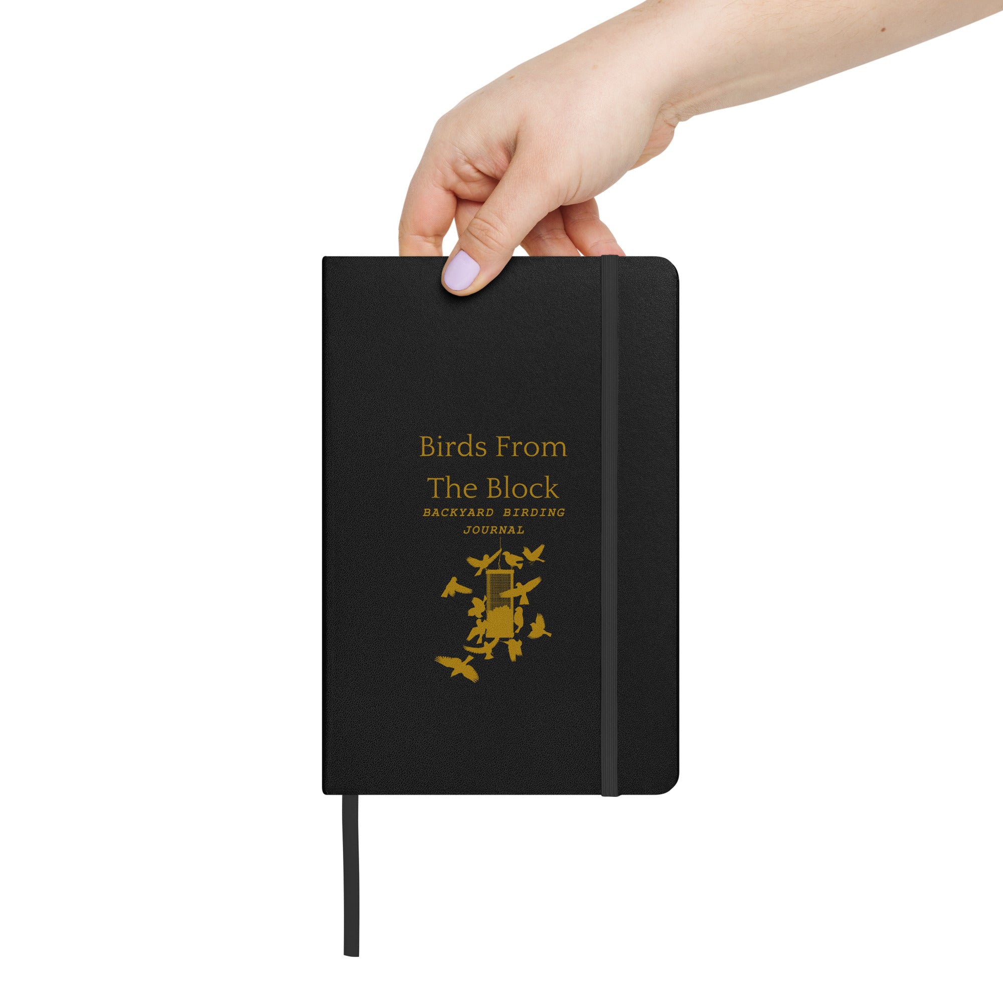 Hardbound birding notebook in black with the words, "Birds From The Block, Backyard Birding Journal" on the front with bird feeder below. Shown held in a hand for scale.