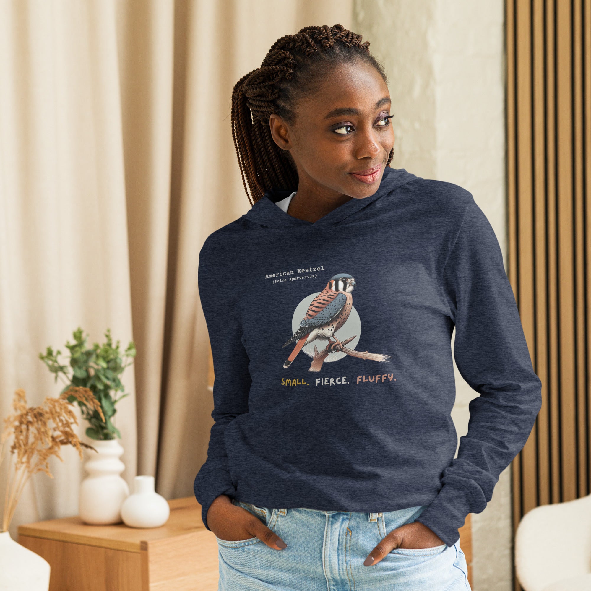 Heather navy long sleeved and hooded unisex bird shirt with the words, "Small. Fierce. Fluffy" below an illustration of an American Kestrel.  Worn by a woman.