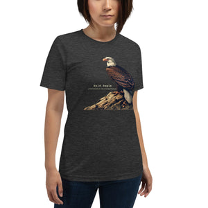 Dark Gray heather unisex bird shirt with a Bald Eagle perched on a rock, next to its common and scientific names. Worn by a woman.