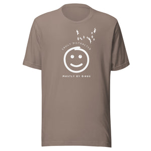Beige grey unisex bird t-shirt with a smiley face looking up and to the side at a flock of birds surrounded by the words, "Easily Distracted" above and, "Mostly by Birds" below.