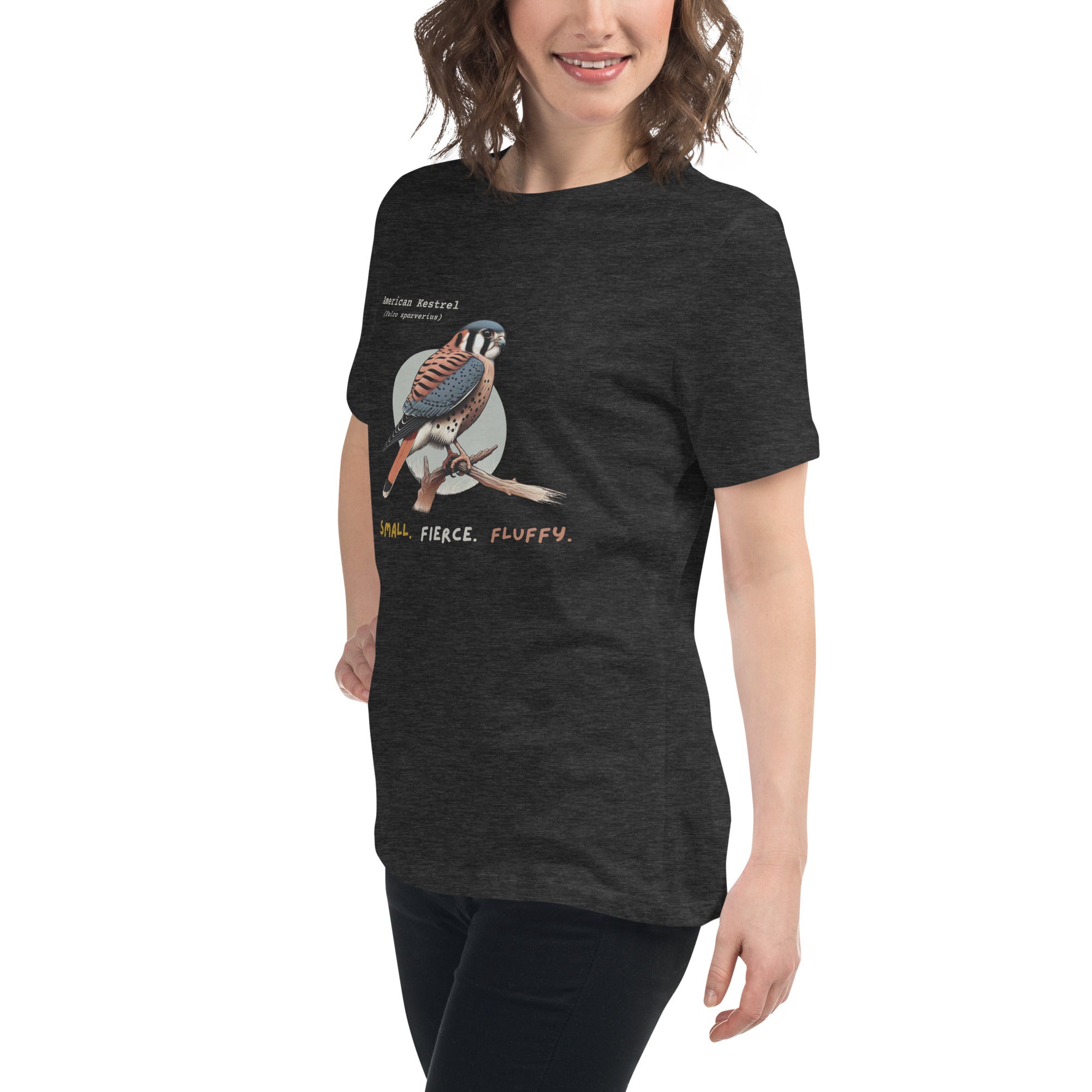 A dark heather gray women's bird shirt with the words, "Small. Fierce. Fluffy" below an illustration of an American Kestrel. Worn by a woman.