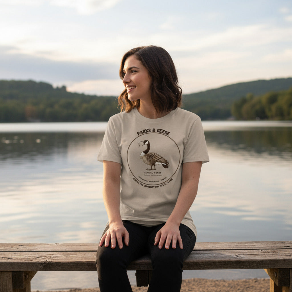 Women's relaxed fit light tan bird shirt with a canada goose on the front and a park department theme. Worn by a woman.