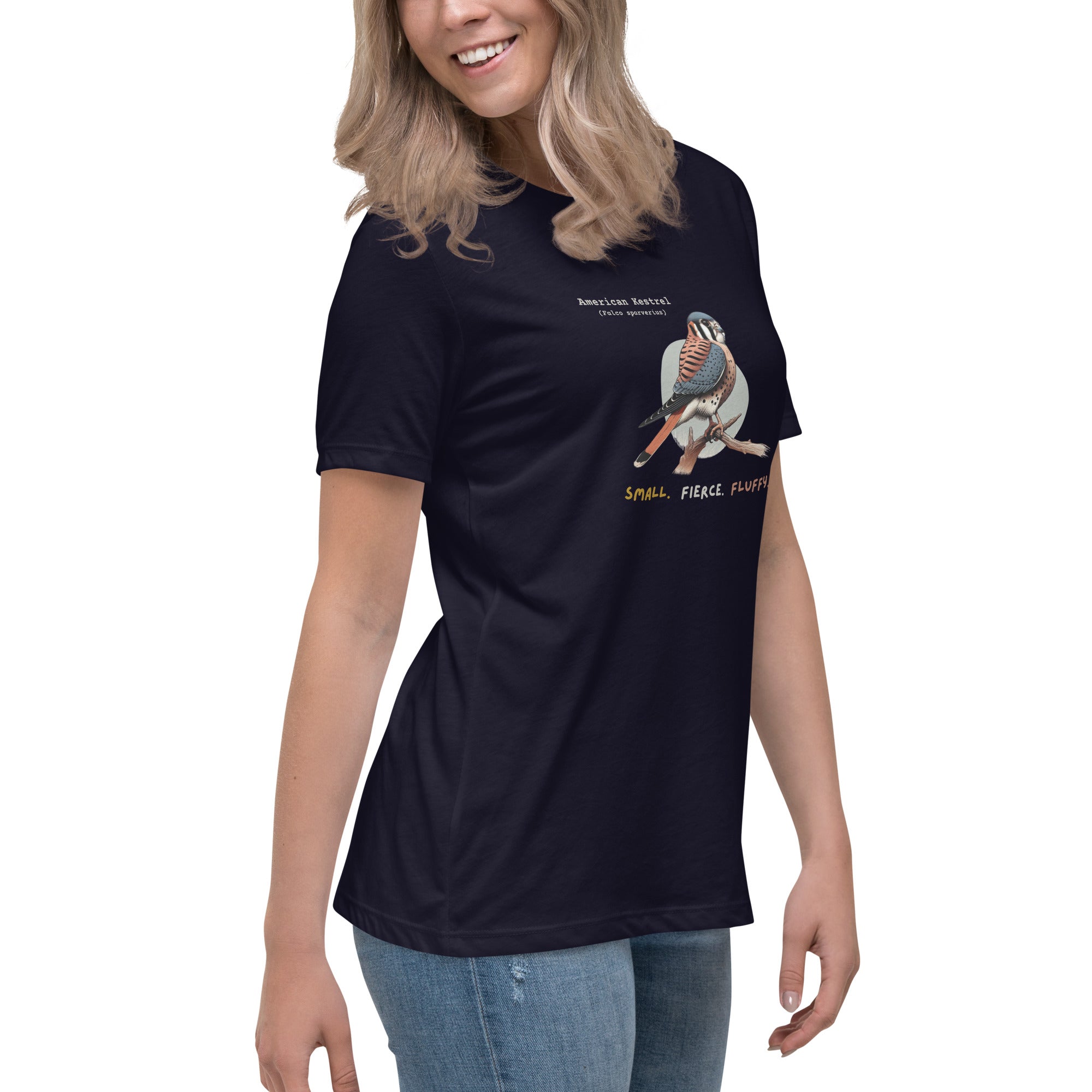 A navy blue women's bird shirt with the words, "Small. Fierce. Fluffy" below an illustration of an American Kestrel. Worn by a woman.