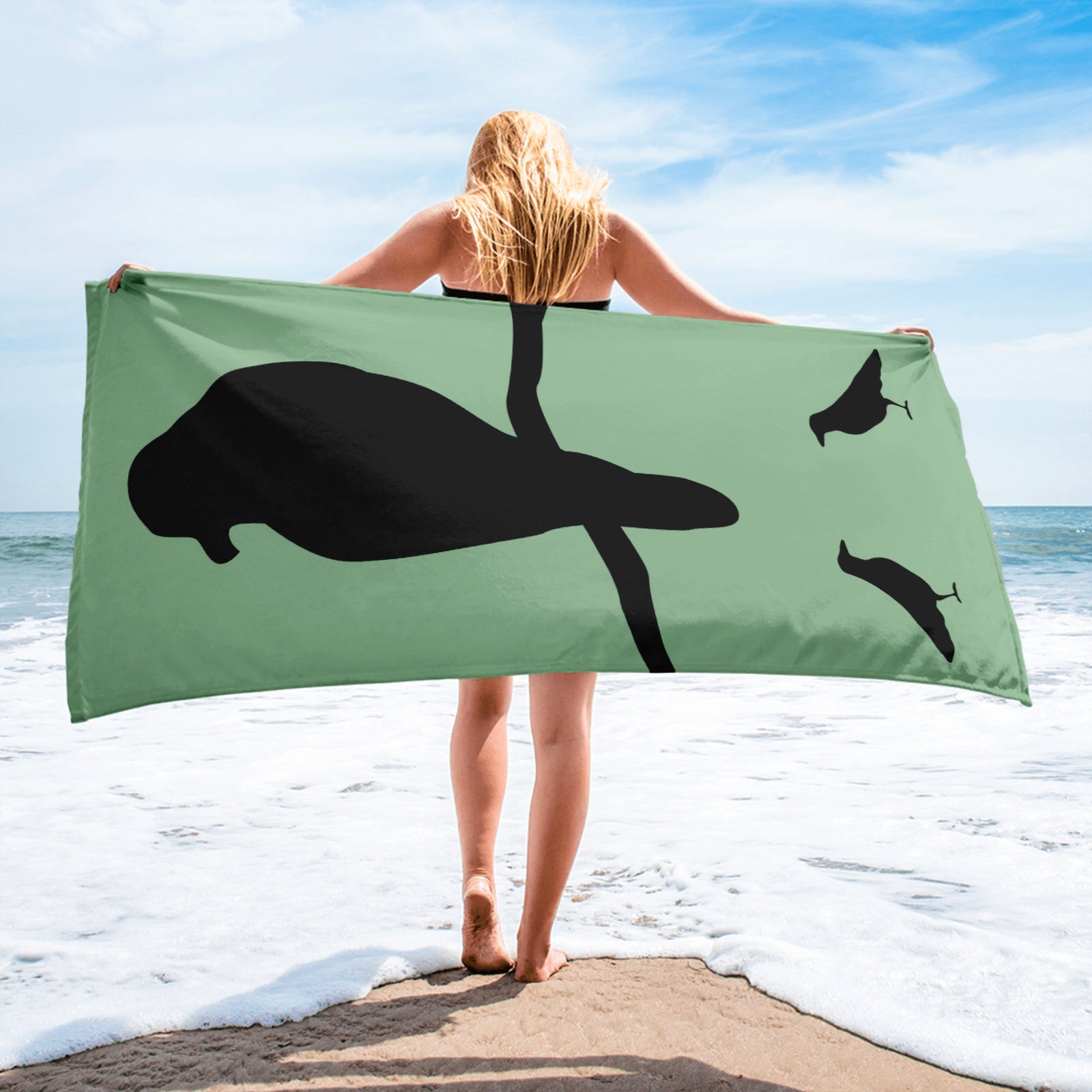 Sea green large beach towel with a large silhouette of a crow on a branch and two smaller standing crow silhouettes beneath.