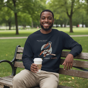 Navy blue unisex bird sweatshirt with the words, "Small. Fierce. Fluffy" below an illustration of an American Kestrel. Worn by a man.