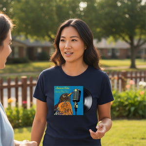 Woman wearing a navy blue t-shirt with a graphic of an american robin, microphone, and vinyl record in a garden setting.
