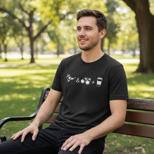 Black heather bird shirt with a bird, binoculars and cup of coffee. Worn by a man sitting on a park bench.
