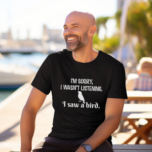Black unisex bird t-shirt with the words I'm sorry I wasn't listening, I saw a bird. And a graphic of a songbird. Worn by a man.
