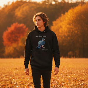 Black, long-sleeve, bird hoodie with a peregrine falcon under the words, Fast, Fierce, Fluffy. Worn by a man walking in a field.