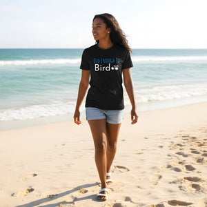 Black bird shirt with the words, "Old Enough To Bird" and a pair of binoculars on the front. Worn by a woman walking on a beach.