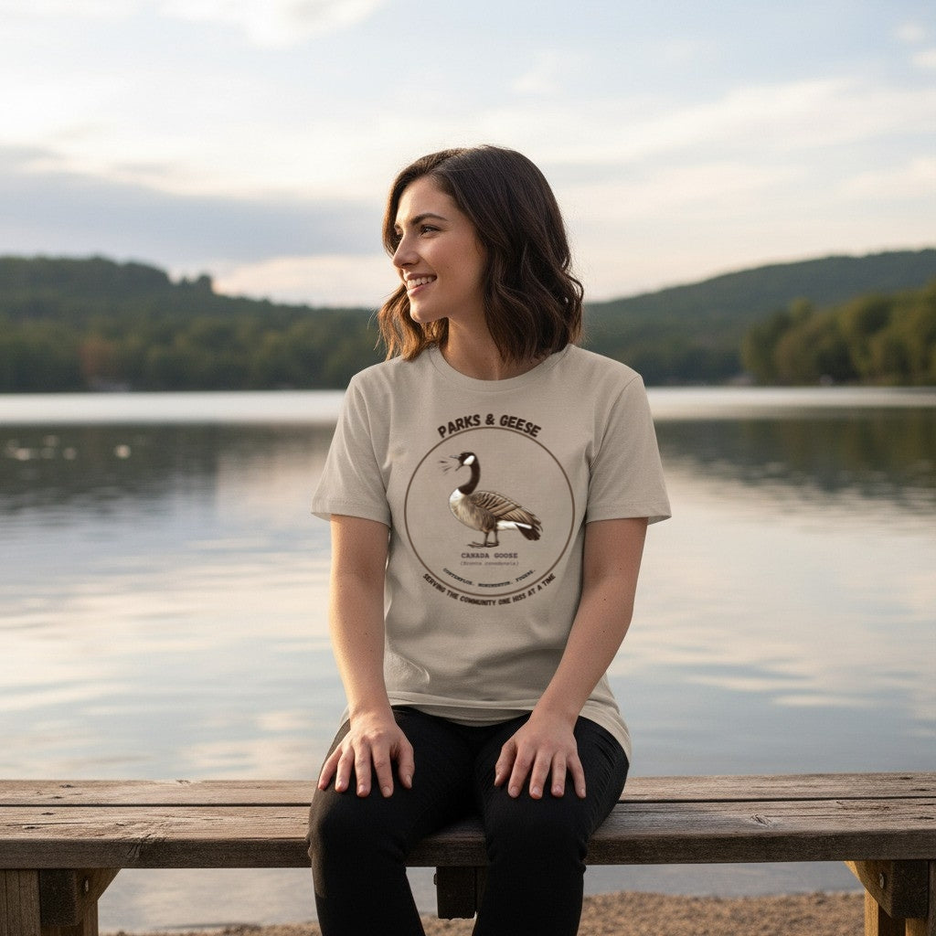 Women's relaxed fit light tan bird shirt with a canada goose on the front and a park department theme. Worn by a woman.