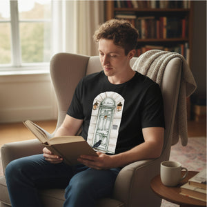 Man wearing an awesome Raven shirt with an Edgar Allen Poe them reading a book in a cozy room with a window and bookshelf in the background