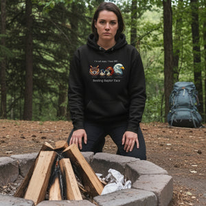 A black bird hoodie with a great horned owl, a peregrine falcon, a red-tailed hawk and a bald eagle. The shirt has text that says, I'm not angry, I have RRF. Resting Raptor Face. Worn by a woman.