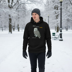Person wearing a black hoodie with a snowy owl design in a snowy park