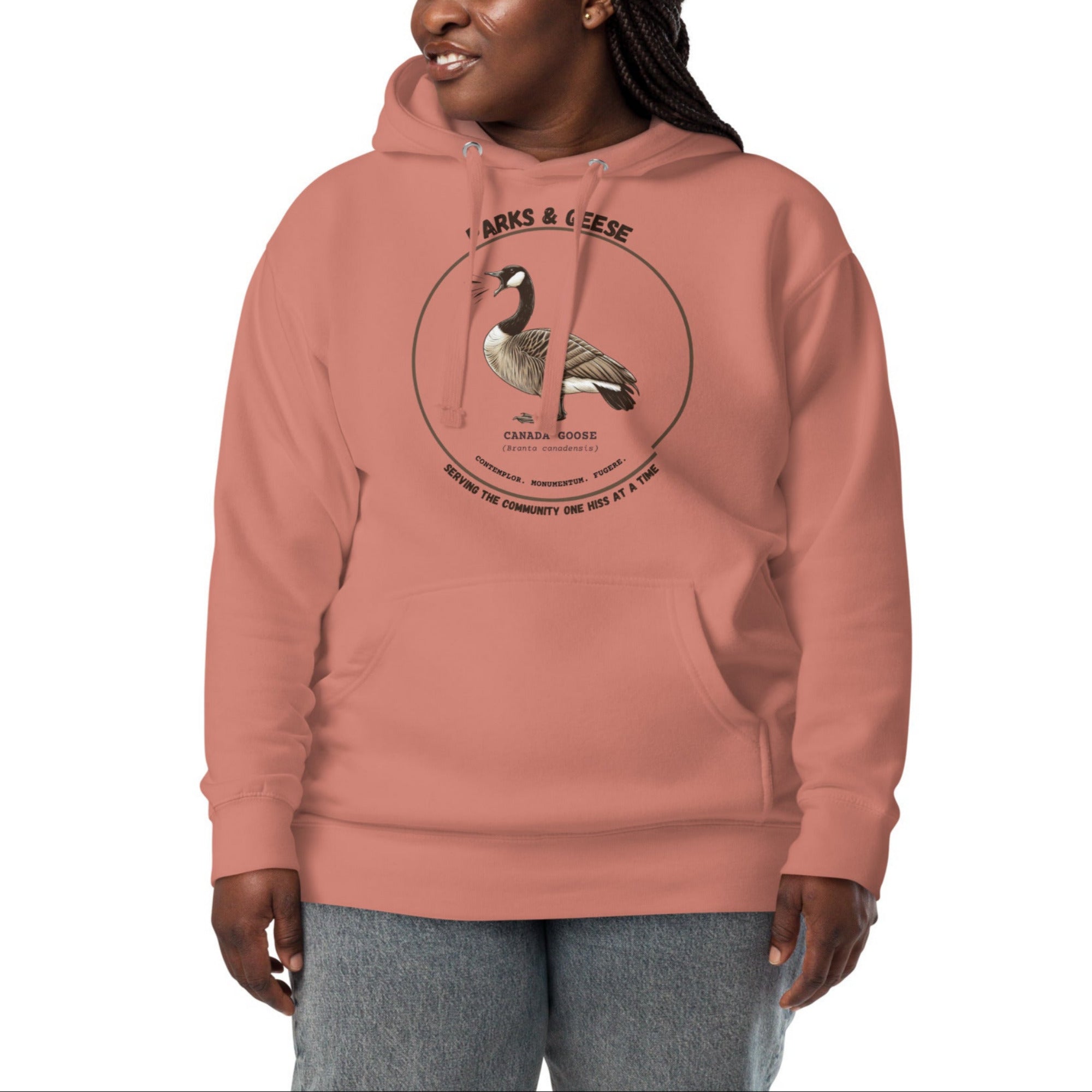 Unisex dusty rose bird hoodie with a canada goose on the front and a park department theme. Worn by a woman.