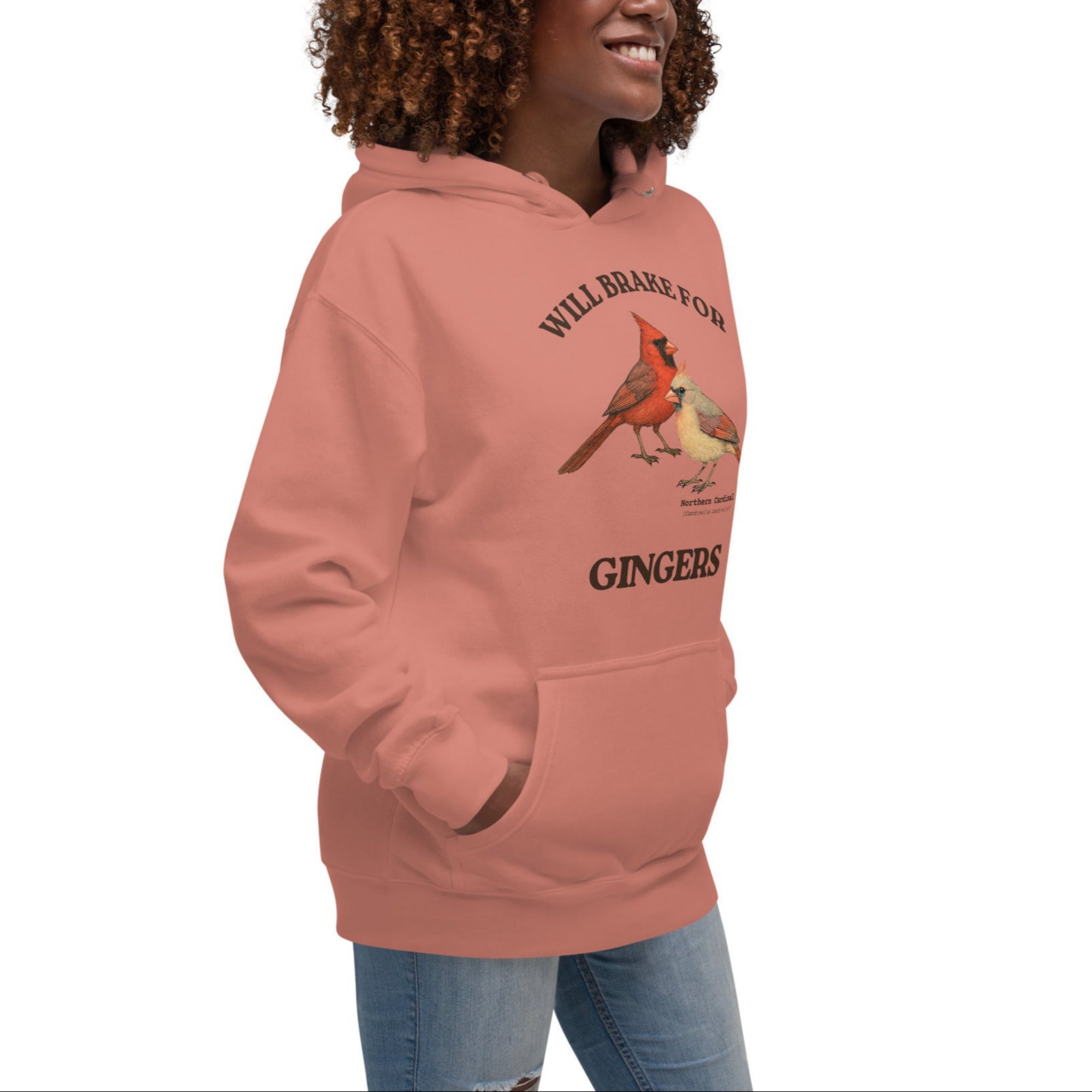 Unisex dusty rose bird hoodie with a male and female northern cardinal and the words, "Will Brake for Gingers" Worn by a woman.