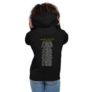 Concert style unisex hoodie in black; featuring an American Robin. View shows back of shirt which has dates and names of towns across America where you might hear an American Robin. Worn by a woman.