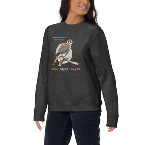 Dark heather gray unisex bird sweatshirt with the words, "Small. Fierce. Fluffy" below an illustration of an American Kestrel. Worn by a woman.
