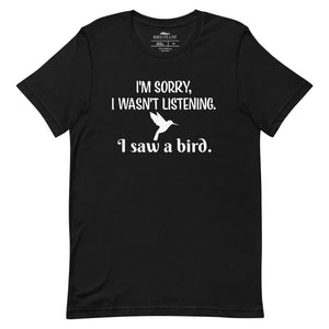 Black bird t-shirt with the words I'm sorry I wasn't listening, I saw a bird. And a graphic of a hummingbird flying. 