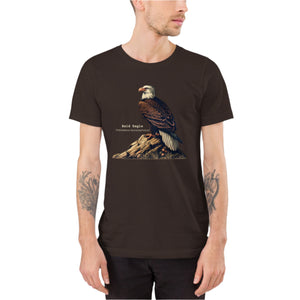 Brown unisex bird shirt with a Bald Eagle perches on a rock, next to its common and scientific names. Worn by a man.