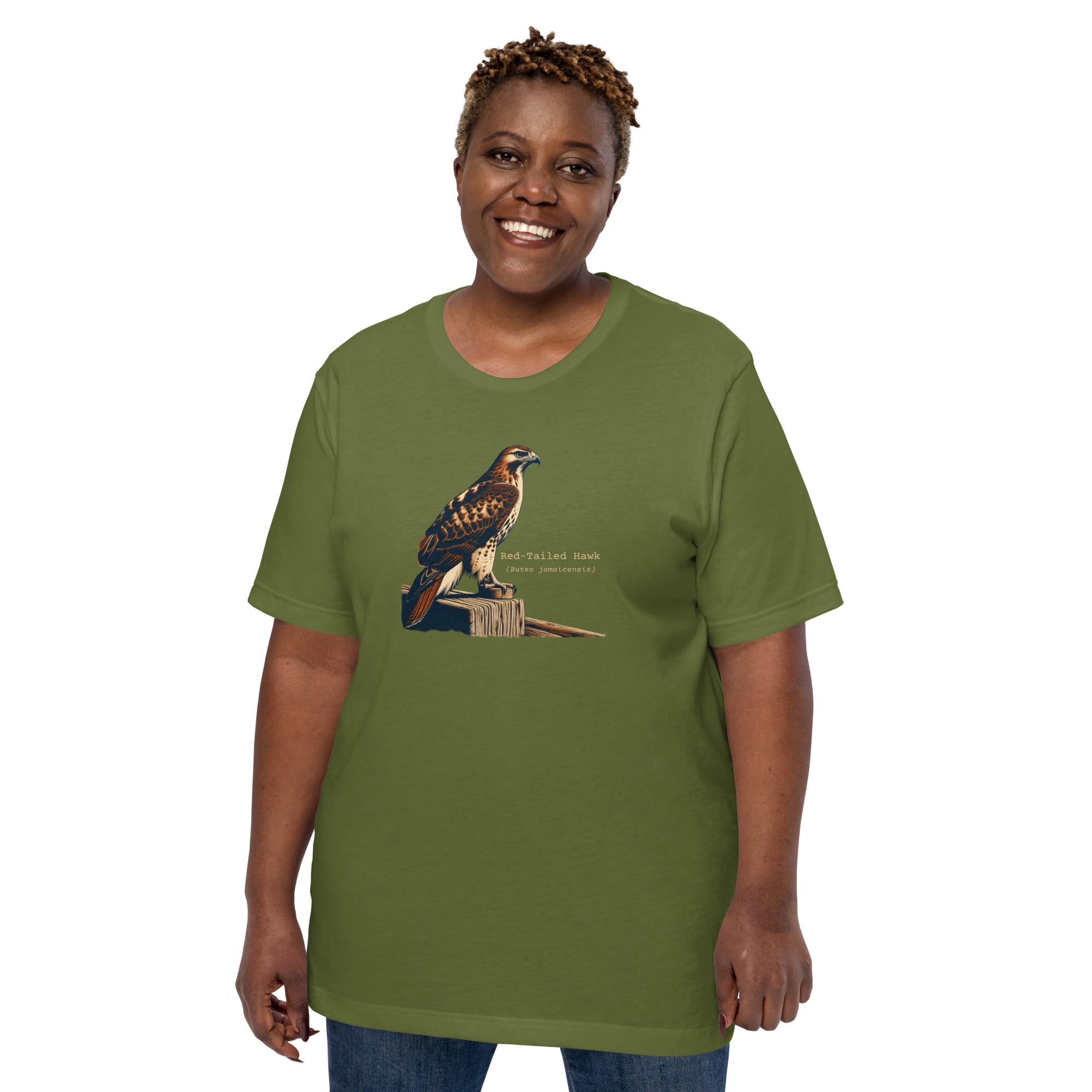 Green bird shirt with an artistic depiction of a red-tailed hawk sitting on a fence and the common and scientific names for the bird next to it. Worn by a woman.