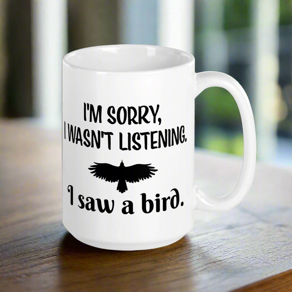 White 15oz mug with the words "I'm Sorry I Wasn't Listening. I Saw a Bird." around the silhouette of a bird flying.