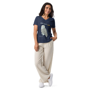 Woman wearing a navy blue t-shirt with a snowy owl graphic and beige pants on a white background