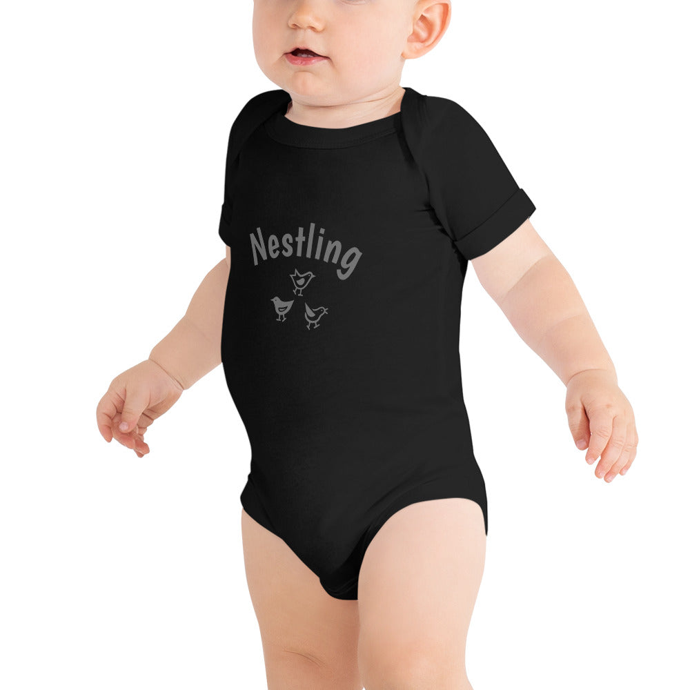 Black one-piece baby suit with the word Nestling on the front above three small birds in grey.